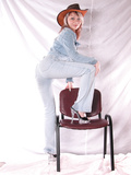 Girl in hat poses on the chair