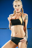 Tattooed female wrestler Sarah Jessie exposes her big tits and sexy tight body