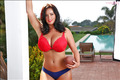 Curvy brunette Sarah Nicola Randall posing with football in bra and panties