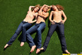 3 topless girls pull their blue jeans down over their bare asses on the lawn