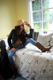 Solo girl Nina James takes off blue jeans to model in cowgirl boots and hat